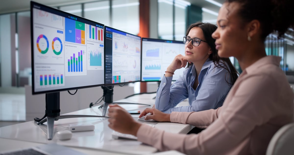 Equipo de analistas revisando datos y gráficas de rendimiento en una laptop en la oficina